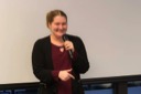 Technologist Jessica Rose speaks at the You Got This conference. She is smiling broadly as she presents to the audience.