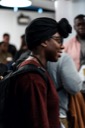 An attendee wearing a black head scarf smiles as she talks to someone out of shot.